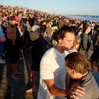 Hundreds gather in Huntington Beach to be baptized with cold dunk in the ocean