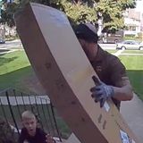 UPS driver sprints across busy street to rescue a young boy pinned under a heavy package