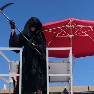 A Florida man visiting beaches dressed as the Grim Reaper says governor should require masks statewide