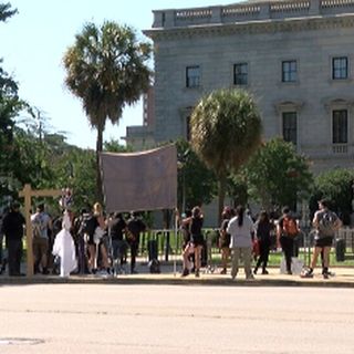 Protestors outnumber pro-Confederate flag organizers during flag raise at the State House